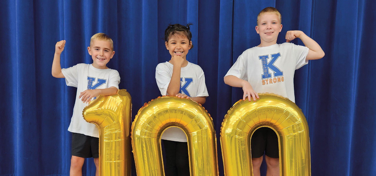 Kelso kids posing with a golden 100 balloon