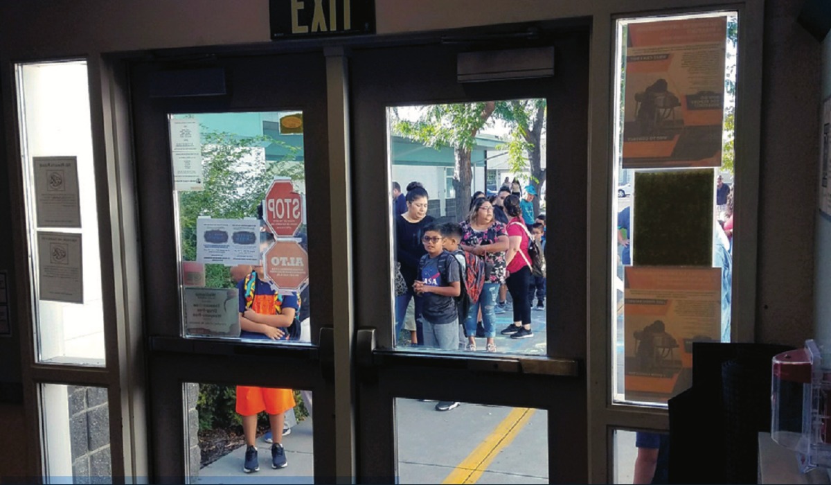 Students and parents waiting at a closed door.